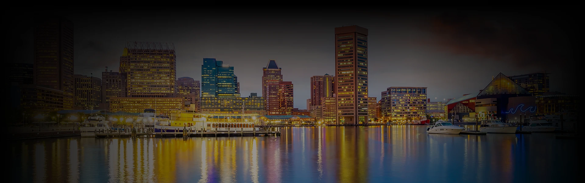 Baltimore’s waterfront skyline at dusk with glowing buildings and yachts, overlaid with 'Washington DC to Baltimore Car Service' highlighting luxury travel between cities.